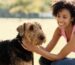 Woman smiling while petting a dog.